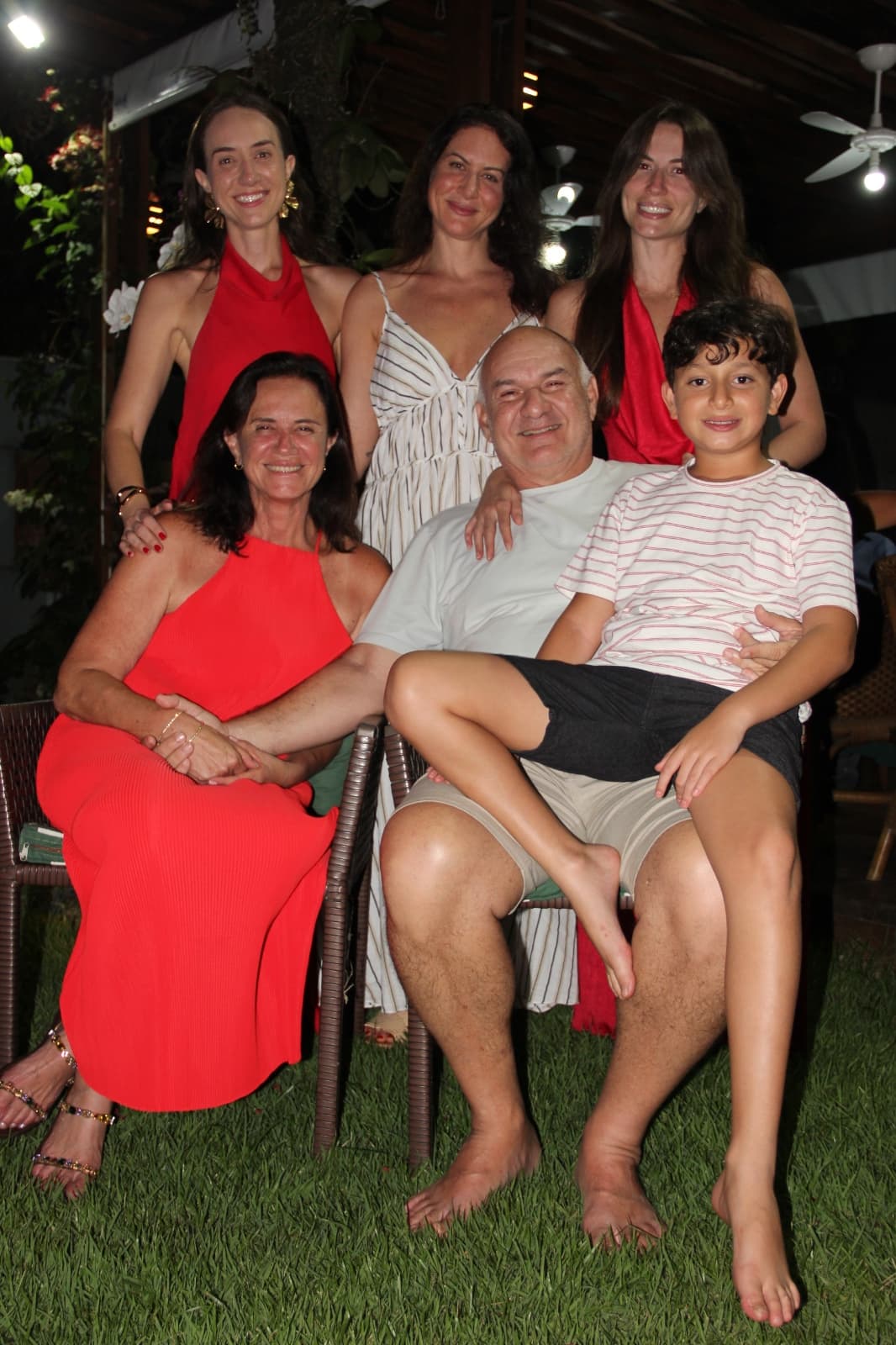 Marcão sentado com a esposa Adriana e o neto Marco Antônio no colo, com as três filhas em pé atrás