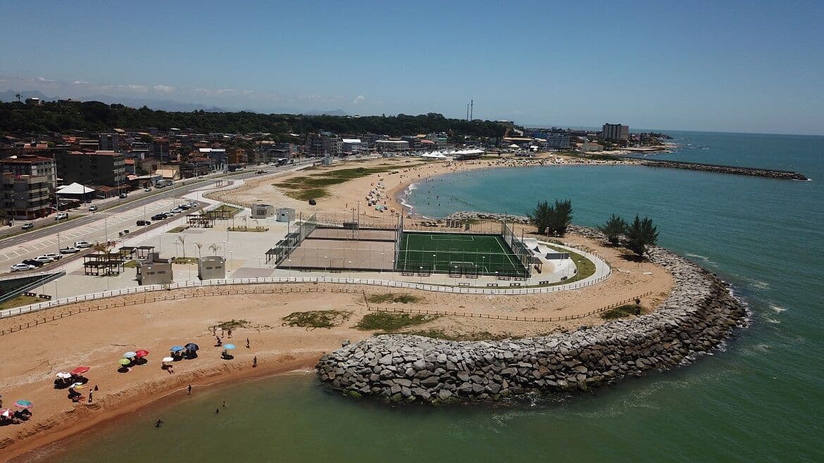 Vista aérea da orla de Marataízes, com a praia, o quebra-mar e as quadras da orla
